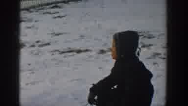 Wisconsin USA (1957): Dog Walking Up To Little Boy Sitting In The Snow