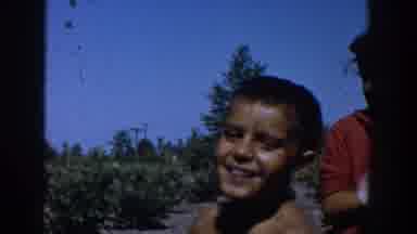 Michigan USA (1958): A Boy Smiles As A Girl Behind Him Wipes Her Arm With A Towel