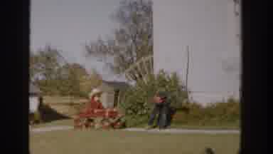 Michigan USA (1958): Boy Pulls Girl Wearing Red Coat Sitting In Red Wagon On Front