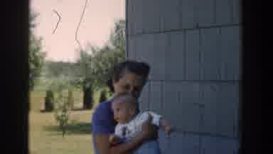 Michigan USA (1958): A Mother Holding Her Baby In The Warmth Of The Sun