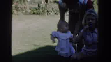 Michigan USA (1958): Adult Holding Babies Hands While Baby Tries To Stand And Walk
