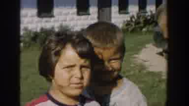 Michigan USA (1958): Two Children Eating In Yard On A Windy Sunny Day