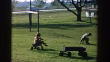Michigan USA (1958): Three Kids Are Playing With Wheel Kit And Two Vehicles Are