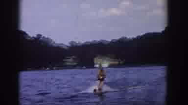 Wisconsin USA (1958): Person Water Skiing Sports On Water With Forest And Mountain