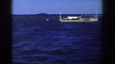 Wisconsin USA (1958): Long Flatbed Boat Seems To Be Hauling Loads Across Lake