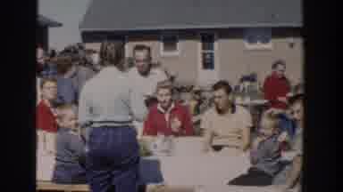 Wisconsin USA (1958): A Group Of People Sitting Down And Standing Outdoors Eating
