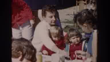 Wisconsin USA (1958): Group Of People Outdoors And Kids Being Fed