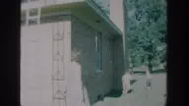 Wisconsin USA-1964: Two Children Play Outside Brick House With Bicycle