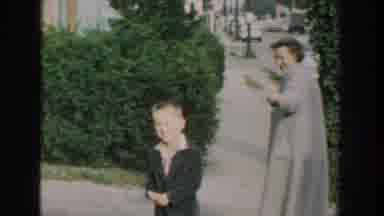 Wisconsin USA (1964): A Little Boy And An Old Woman On The Street Waving To The