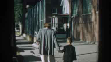 Wisconsin USA (1964): Woman Walking Down A Street With A Young Boy