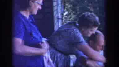 Wisconsin USA (1964): Older Members Of Family Stand On Porch And Chat