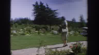 Wisconsin USA (1964): White Lady Walking Down Cement Pathway To Pick Up And