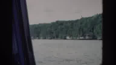 Wisconsin USA (1964): Vegetation Covers A Rocky Cliff Rising From The Shore Of A