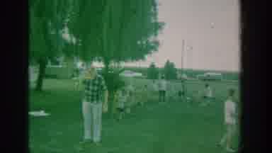 New York USA (1964): Man Eating At A Picnic And Two Elderly Women Standing Outside
