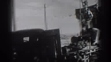 California USA-1936: Man Operating Large Machine on Truck in Rural Roadside Scene