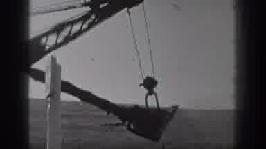 California USA (1936): Black And White Footage Of Man Working Behind A Digger