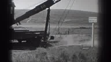 California USA (1936): Machine Digging Up Dirt Near A Railroad By A Hill
