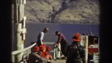 Chelan Washington USA (1939): Men Sit On A Dock By Open Water Near Boat