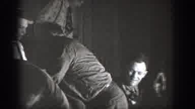 Chelan Washington USA (1939): Man Walks Around Group Of People Wrestling On Wooden