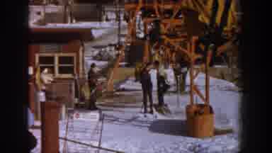 Aspen Colorado USA (1961): Two People Looking Behind Them One Taking Off Coat And