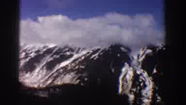 Aspen Colorado USA (1961): A Group Of Snowy Mountains Underneath A Partly Cloudy