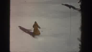 Aspen Colorado USA (1961): Two People Skiing Down A Ski Slope In The Woods In The