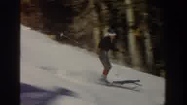 Aspen Colorado USA (1961): A Skier Skis Down A Mountain Slope And Over A Small