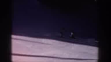 Aspen Colorado USA (1961): A Guy Wearing A Yellow Coat Skiing On Smooth White Snow