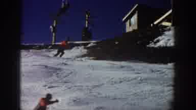 Aspen Colorado USA (1961): Various People Ski Down Snow-Covered Slope With Lodge