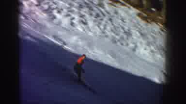 Aspen Colorado USA (1961): Medium Distance Skier In Red On A Shaded Slope Moves