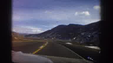 Aspen Colorado USA (1961): Car Driving Down Road With View Of Bare Mountains,