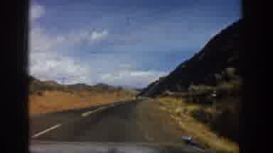 Aspen Colorado USA (1961): A Car Driving Through A Valley With Overhanging Rock