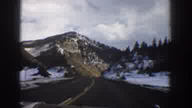 Aspen Colorado USA (1961): A Vehicle Drives Down A Highway Through The Mountains