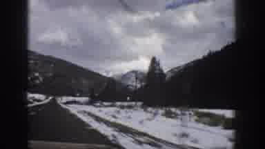Aspen Colorado USA (1961): Driving Down Long Snowy Road With Mountain Landscape In