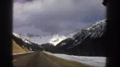 Aspen Colorado USA (1961): Car Driving Down A Snowy Road In The Mountains At Day