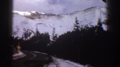 Aspen Colorado USA (1961): Driving Down A Winding Road On The Side Of A Snowy
