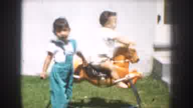 California USA (1952): Children Play On Toys Fixed On The Grass Of The House On