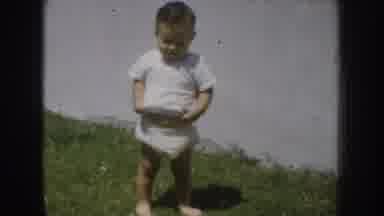 California USA (1952): Child With A Cheat And White T-Shirt With His Mother Taking
