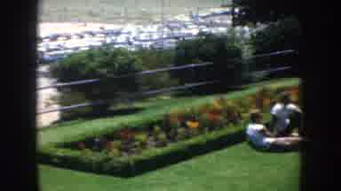 California USA (1952): Park With Green Grass With Flower Beds And A Couple Lying