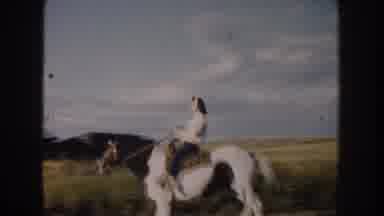 South Dakota USA (1953): Person Riding A Galloping Horse Through Field Near Stable