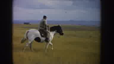 South Dakota USA (1953): Man Riding Horse With A Blue Sky And Green Grass