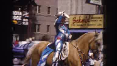 South Dakota USA (1954): Cowgirl In Blue Riding A Horse Leads Marching Band In