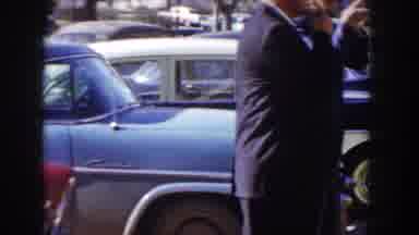 Idaho USA (1955): Women In Blue Dress Waiting For A Car From Men Who Want To Show