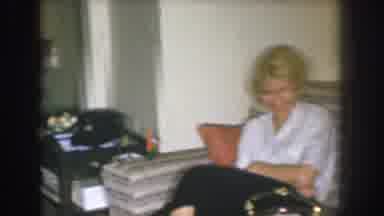 Nebraska USA (1955): A Women Sitting In A Living Room Accompanied By Someone