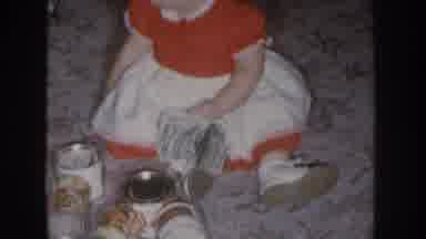 Nebraska USA (1955): Baby Girl On Floor In Red And White Dress With Money