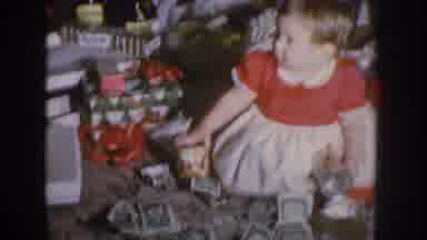 Nebraska USA (1955): Young Girl Sitting In Money And Various Other Gifts Is