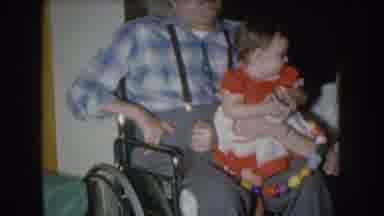 Nebraska USA (1955): Daughter Sitting On Disabled Father's Lap In A Wheelchair Mom
