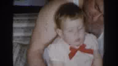 Nebraska USA (1955): A Man Taking Care A Baby Playing In Bed