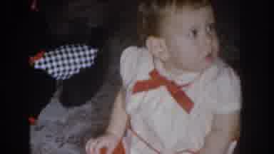 Nebraska USA (1955): Baby Girl Playing With Toy Dog While Parents Try To Get Her