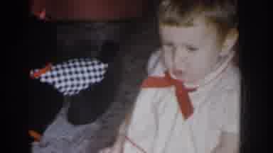 Nebraska USA (1955): Toddler Looking Confused, Wearing A Dress In With A Red